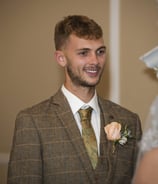 Grooms first look, smiling warmly during a wedding ceremony, wearing a checkered suit