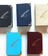 a group of four books with a pen and pencil