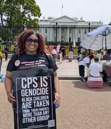 Lucky in front of White House wearing Black Mothers March shirt & holding a "CPS is Genocide" sign. 