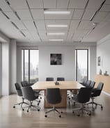 A dimly lit room features a prominent illuminated sign displaying the words 'Sysco LABS.' Below the sign are office desks with various electronic devices, including laptops and cables. The lighting creates a cool and professional atmosphere.