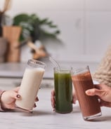 three people holding drinks in a kitchen