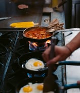 a person cooking food on a stove top