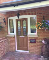 oak wood colour composite door with decorative glass and half glazed side panels 
