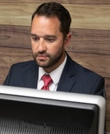 a man in a suit and tie is sitting at a desk