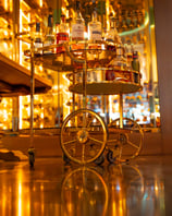 a bar cart with bottles of alcohol and liquor