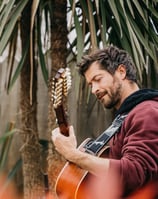 a man playing guitar in a garden