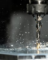 CNC machine is drilling a piece of metal