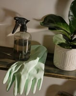 a green gloved hand held cleaning gloves and a green glove