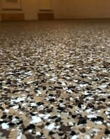 Epoxy garage floor in Lincoln home- Brown, white, and black epoxy flakes 