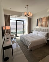 a bedroom with a bed and a large window