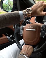 a man driving a car with a watch on his wrist