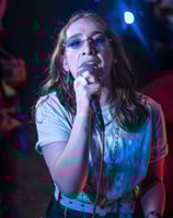 a woman in sunglasses and sunglasses is holding a microphone