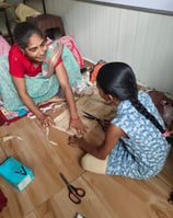 teacher sewing w young girl