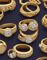 Two intricately designed gold bangles are displayed against a luxurious red velvet background, highlighting the jewelry's elegance and craftsmanship.