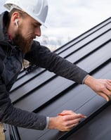 un ouvrier en rénovation énergétique construit une toiture moderne