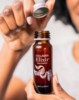 a woman holding a bottle of elixix elixixix