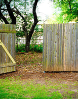 Wooden fence with repaired gate bracing in residential backyard