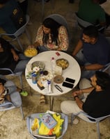 a group of people sitting around a table at basil the otherside