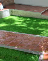 Pasto sintético verde y duradero instalado en un patio trasero