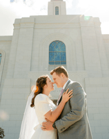 a bride and groom standing in front of a church