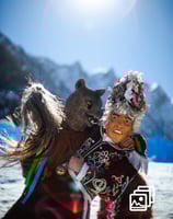 a man in a costume with a bear during carnival in winter