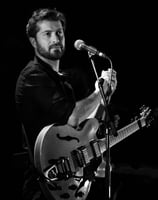 a man with a guitar and microphone