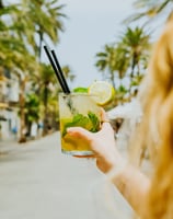 Cóctel mojito refrescant a la terrassa de Santa Lola Badalona amb palmeres de fons.