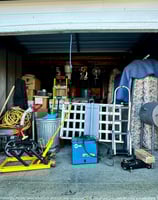 a garage with a garage door open and a lot of junk, garage, storage unit,