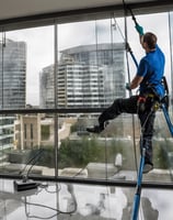 man hanging on building near woman in window during daytime