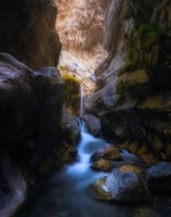 a waterfall in a canyon with a waterfall flowing down it. arbab naimat kasi balochistan Moola Chotok