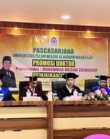 a group of people sitting at a table with a banner on it