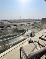 a balcony with a table and chairs and a view of the city