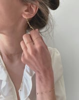 Photo bijoux BYNORA portés. Chaîne d'oreilles, bagues, sautoir et bracelet avec des diamants bruts multicolors