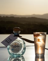 a bottle of tequila in a glass with a bottle of tequila
