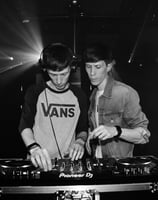 two men standing in front of a dj booth