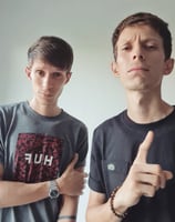 two men standing next to each other with their hands on their hipss