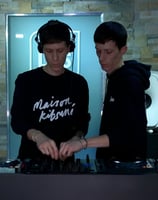 two men standing in front of a dj booth