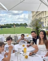 a family sitting at a table with a man and two children