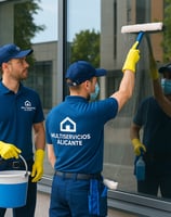 Trabajadores limpiando cristales con uniforme y logo de elMultiservicios