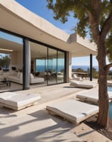 A luxury white villa with large windows and a green roof is situated on a scenic hillside. A man in sunglasses and swimwear is casually seated on a wooden railing, enjoying the warm sun.