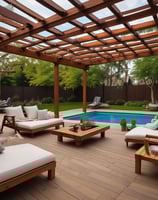 A luxury white villa with large windows and a green roof is situated on a scenic hillside. A man in sunglasses and swimwear is casually seated on a wooden railing, enjoying the warm sun.