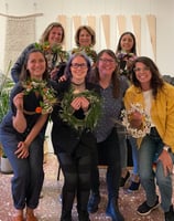 a group of women standing and showcasing wreaths