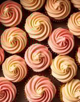Delicious cupcakes with light yellow and dusty pink frosting swirled in rosettes ordered from Claire