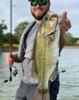 a man holding a fish on a kayak