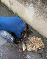 a man is sitting on the ground next to a trash can