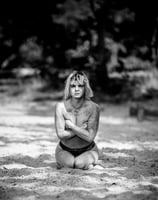 a woman sitting on a beach with her arms crossed and arms crossed