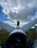 a man standing on top of a turbine