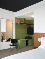 a bedroom with a bed, desk, and chair