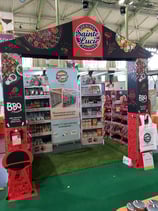 Photo d'un stand avec une arche, des boxes de produits et un roll-up sur le thème des barbecues