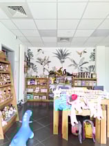 Réalisation du magasin de jouets avec vue sur du papier peint fleuri et des mobiliers en bois